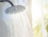 Warmes Wasser fließt aus einem Duschkopf
